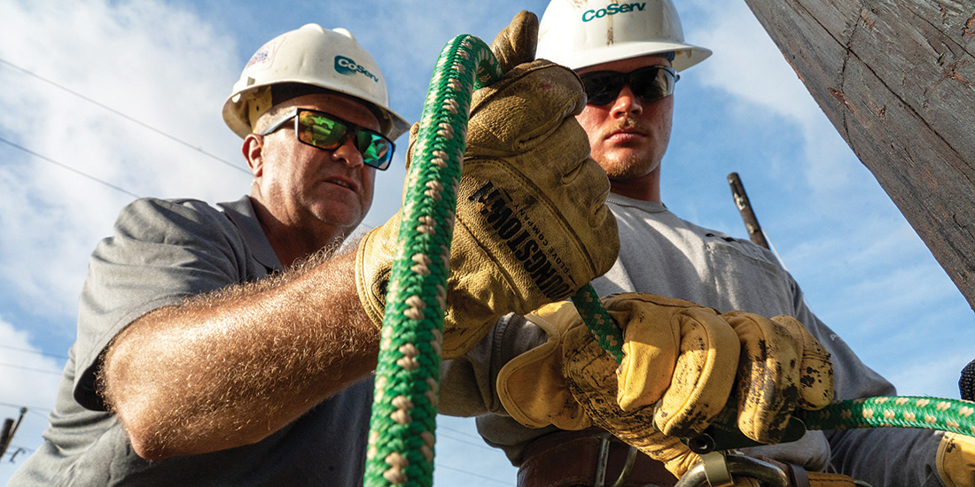 CoServ’s Job Training and Safety Specialist Luke Hawkins shows Lineman Meryk Slattery how to adjust his primary climbing line 
with a BuckSqueeze during the CoServ Climbing School. Photos by BRIAN ELLEDGE
