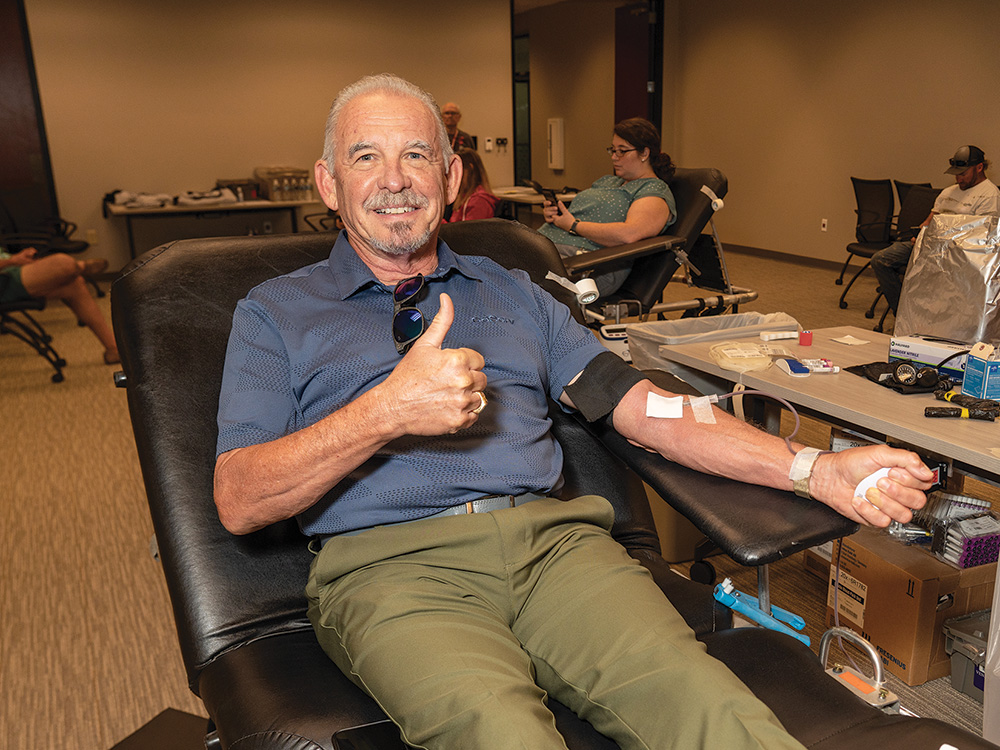K: Vice Chairman and District 6 Director, Bill Ragsdale, donates blood at the fall CoServ-sponsored Red Cross blood drive.