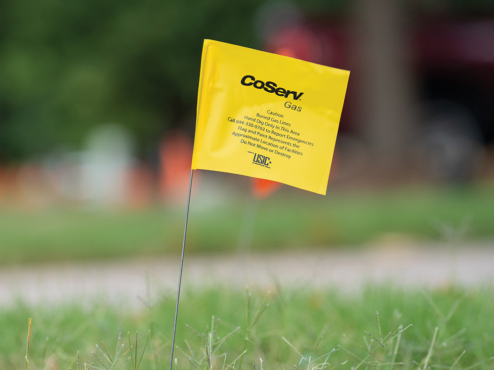 Flag used place by USIC to mark CoServ Gas lines during digging in a yard while new fiber lines were being laid in Mckinney.