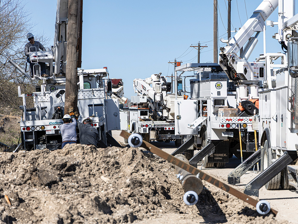 Trabajadores de la red eléctrica instalando un nuevo poste en Frisco, a lo largo de la futura ampliación de Panther Creek Parkway.